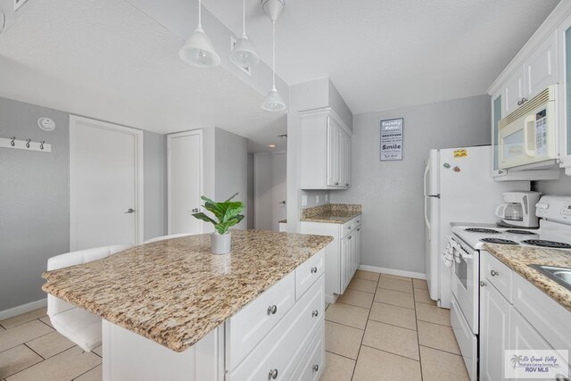 kitchen with a kitchen island, white cabinets, decorative light fixtures, white appliances, and light tile patterned floors