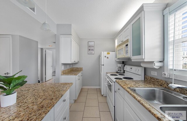 kitchen with white cabinets, a healthy amount of sunlight, white appliances, and sink