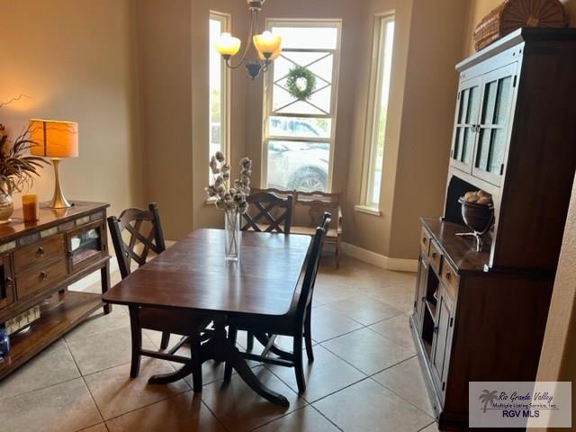 dining room with light tile patterned flooring and a chandelier