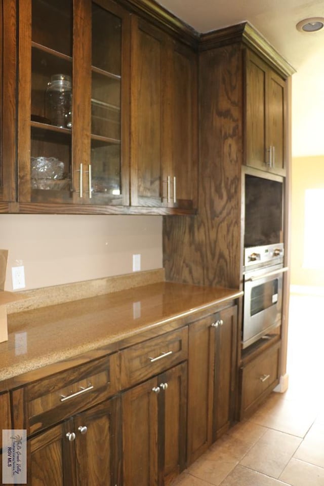 kitchen with wall oven and light tile patterned floors