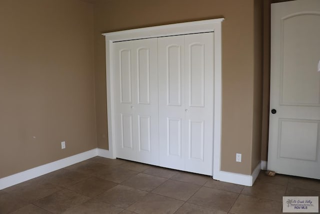 unfurnished bedroom with tile patterned floors and a closet