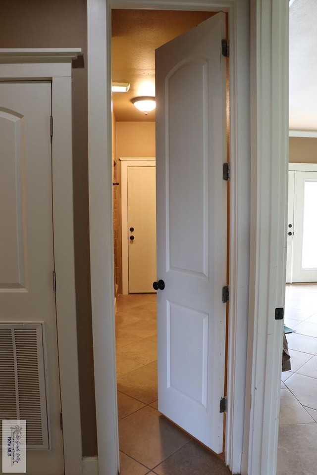 hall with light tile patterned floors