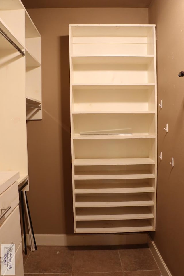 spacious closet featuring dark tile patterned flooring