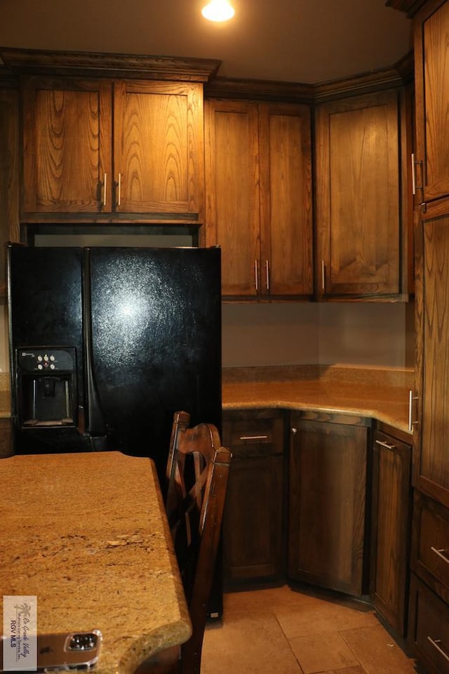 kitchen featuring light tile patterned flooring and black fridge