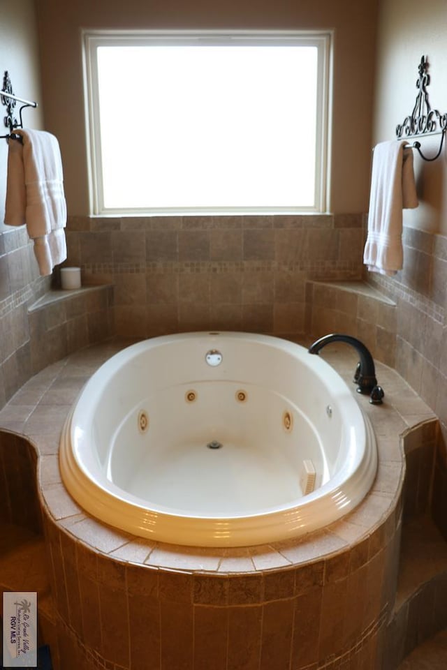 bathroom with plenty of natural light and a relaxing tiled tub