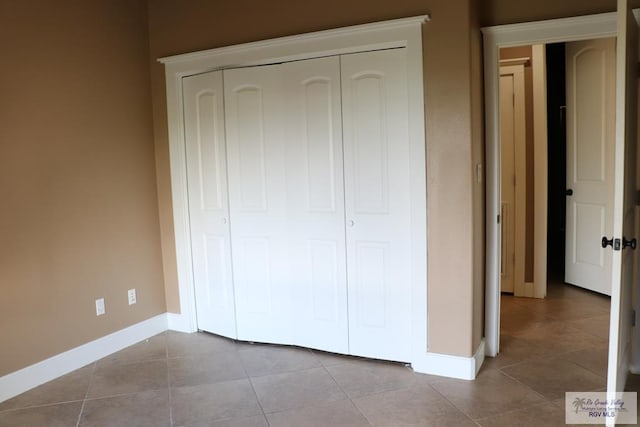 unfurnished bedroom featuring a closet and light tile patterned flooring