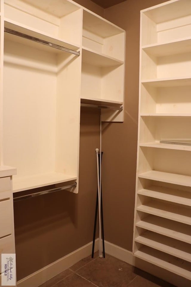 spacious closet with dark tile patterned flooring