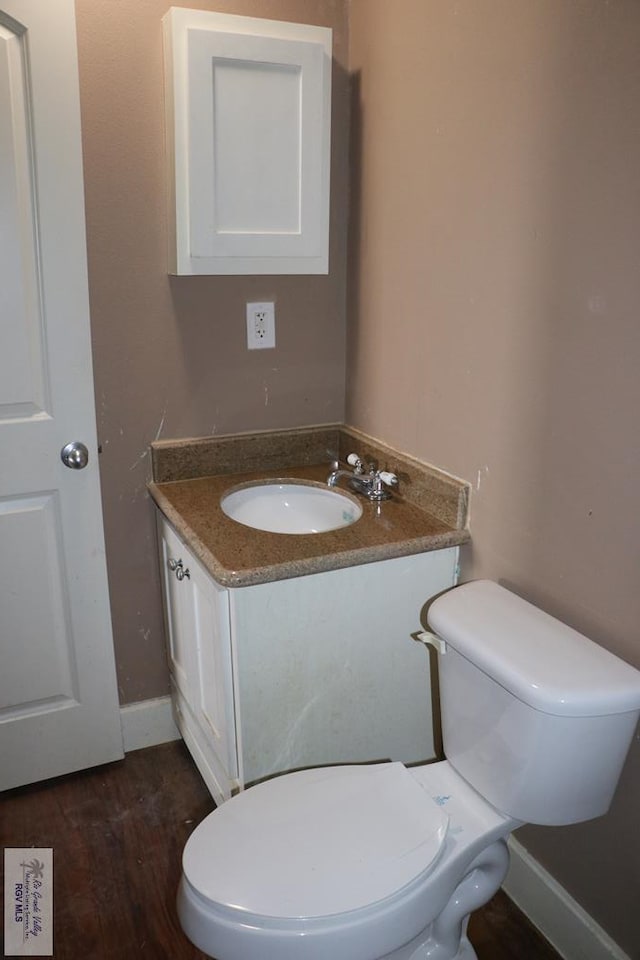 bathroom with vanity, hardwood / wood-style flooring, and toilet