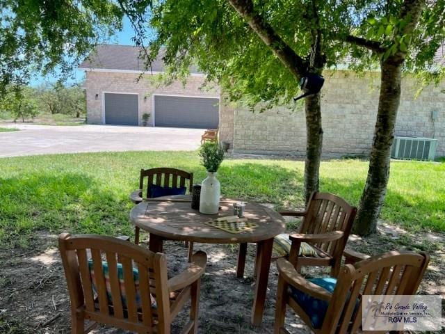 view of patio with central AC unit and a garage