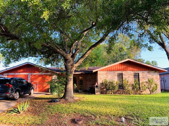 single story home with a garage, driveway, a front lawn, and brick siding