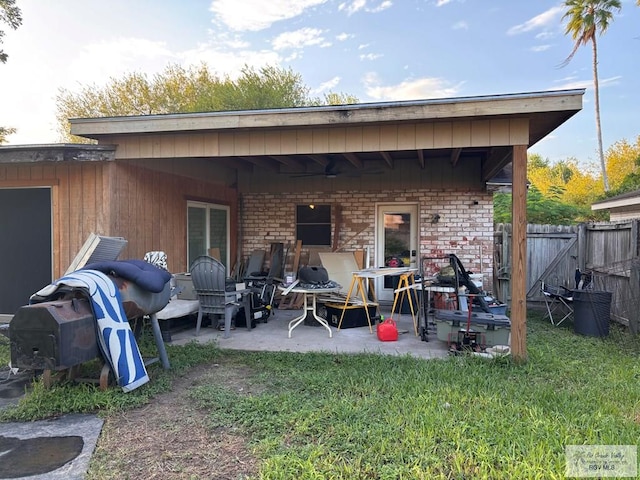 back of property with brick siding, fence, and a patio area