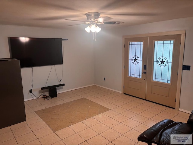 foyer entrance featuring light tile patterned floors, baseboards, ceiling fan, and french doors