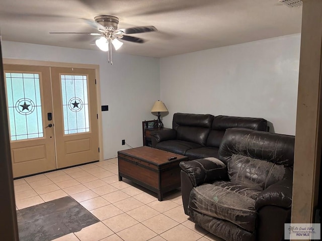 living room with light tile patterned floors, a ceiling fan, and french doors