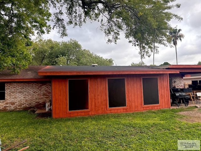 rear view of house featuring a patio and a yard