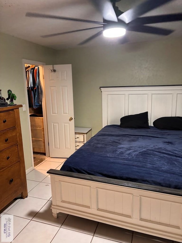 bedroom with a ceiling fan, light tile patterned flooring, and a spacious closet
