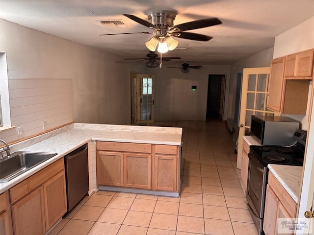 kitchen featuring visible vents, a ceiling fan, a peninsula, a sink, and stainless steel appliances