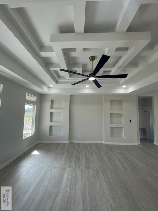 unfurnished living room with visible vents, built in shelves, coffered ceiling, and baseboards