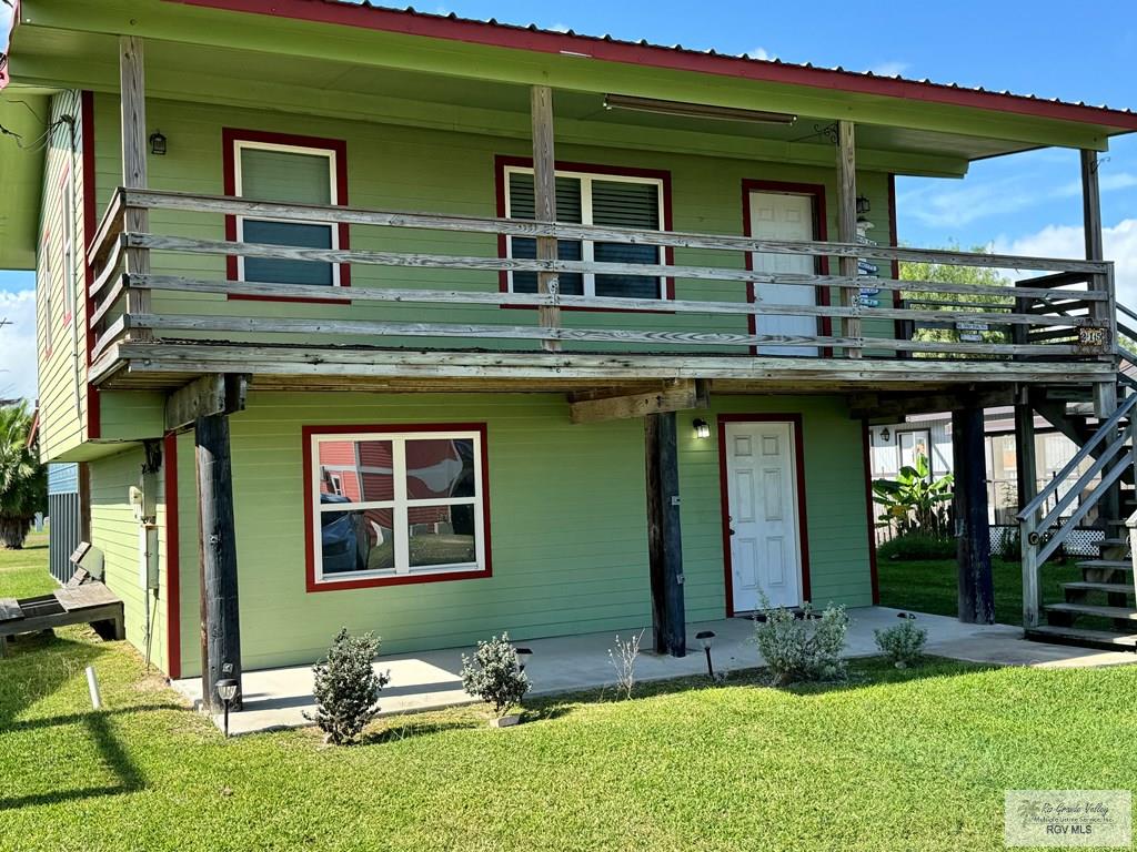 rear view of property with a deck and a lawn