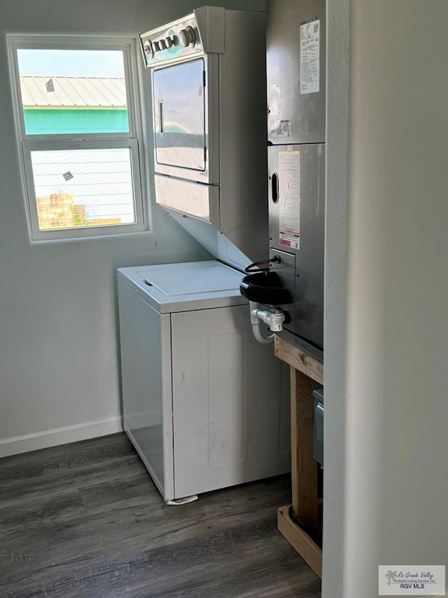 laundry area with dark wood-type flooring and stacked washer / drying machine