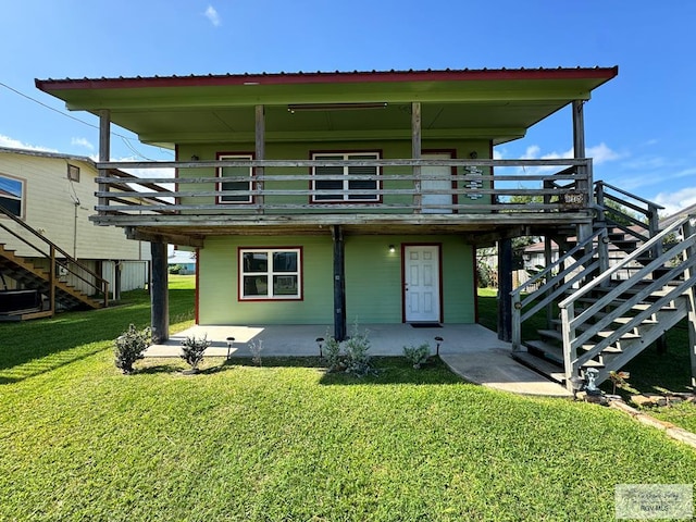 rear view of house with a lawn, a patio area, and a deck