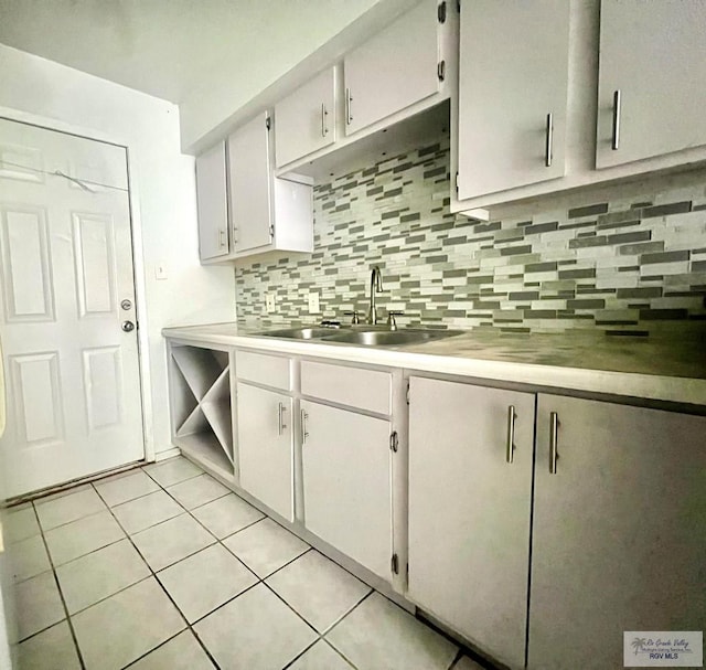 kitchen featuring light tile patterned floors, tasteful backsplash, white cabinetry, and sink