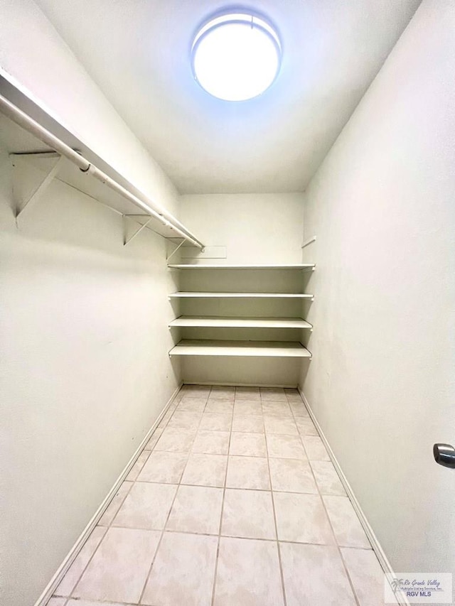 spacious closet with light tile patterned floors