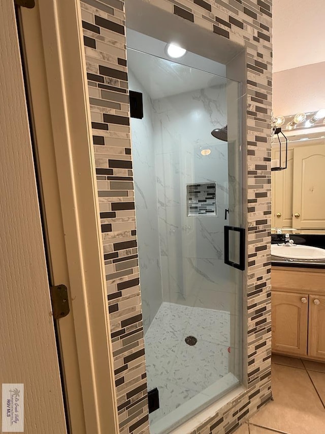 bathroom with walk in shower, vanity, and tile patterned floors