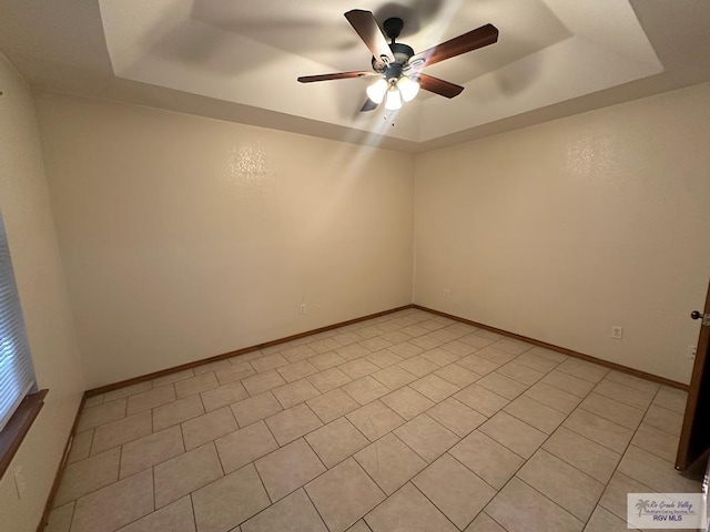 empty room with a raised ceiling and ceiling fan