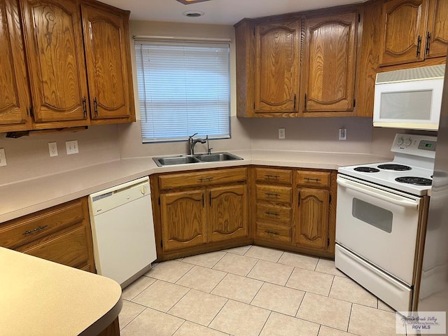 kitchen featuring white appliances, sink, and light tile patterned floors