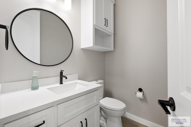 bathroom featuring hardwood / wood-style flooring, vanity, and toilet