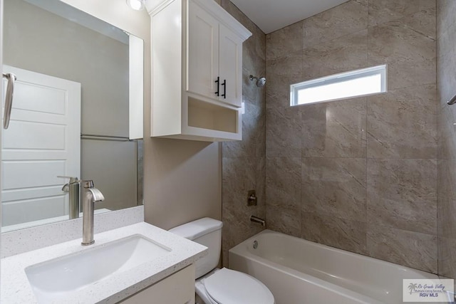 full bathroom featuring vanity, tiled shower / bath combo, and toilet