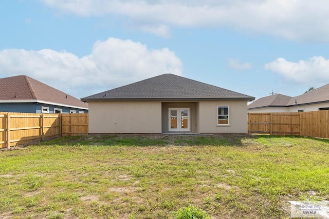 back of house featuring a lawn and french doors