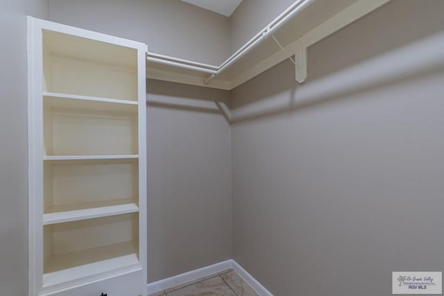 spacious closet with light tile patterned floors