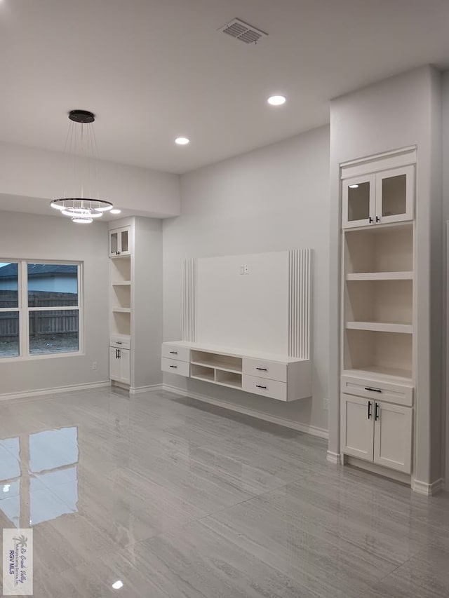 unfurnished living room with a notable chandelier