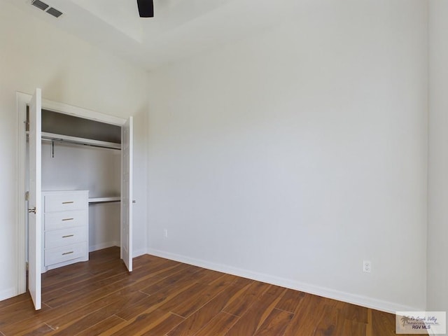 unfurnished bedroom featuring dark hardwood / wood-style floors, a closet, and ceiling fan