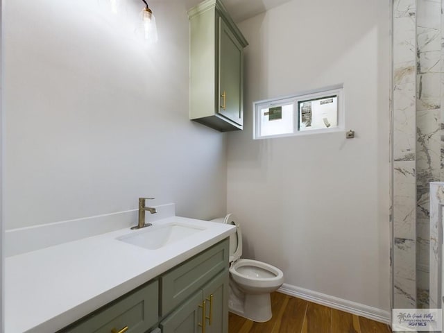 bathroom with wood-type flooring, vanity, and toilet