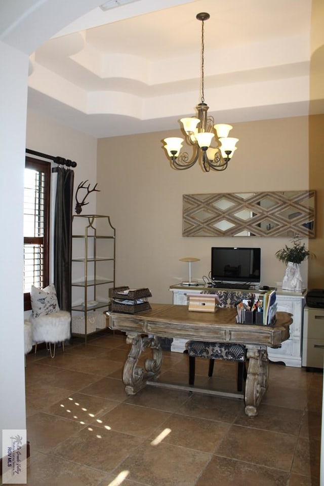 dining space featuring a notable chandelier and a tray ceiling