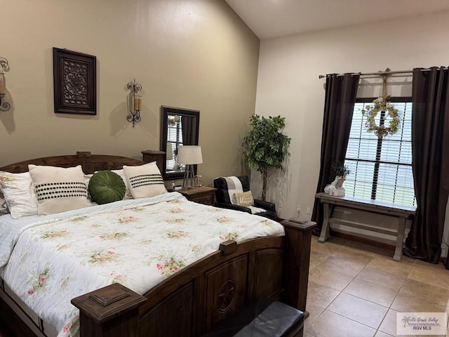 bedroom with multiple windows and light tile patterned floors