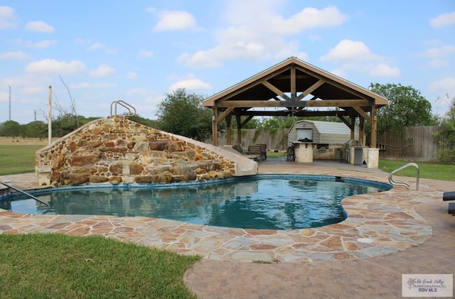 view of swimming pool with a gazebo, an outdoor kitchen, a water slide, and a patio