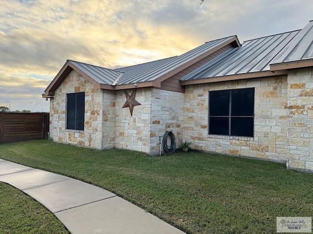 property exterior at dusk with a yard