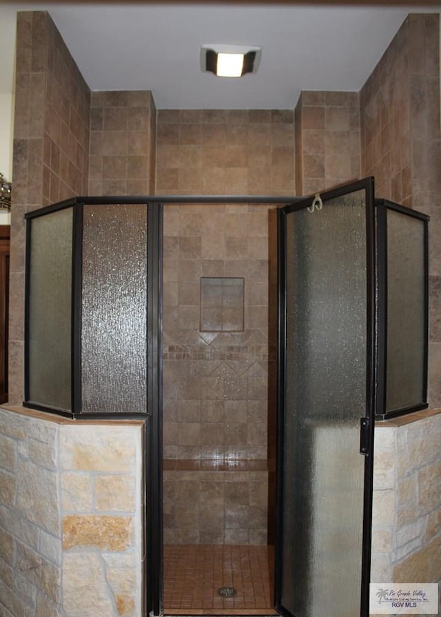 bathroom with vanity and a tile shower