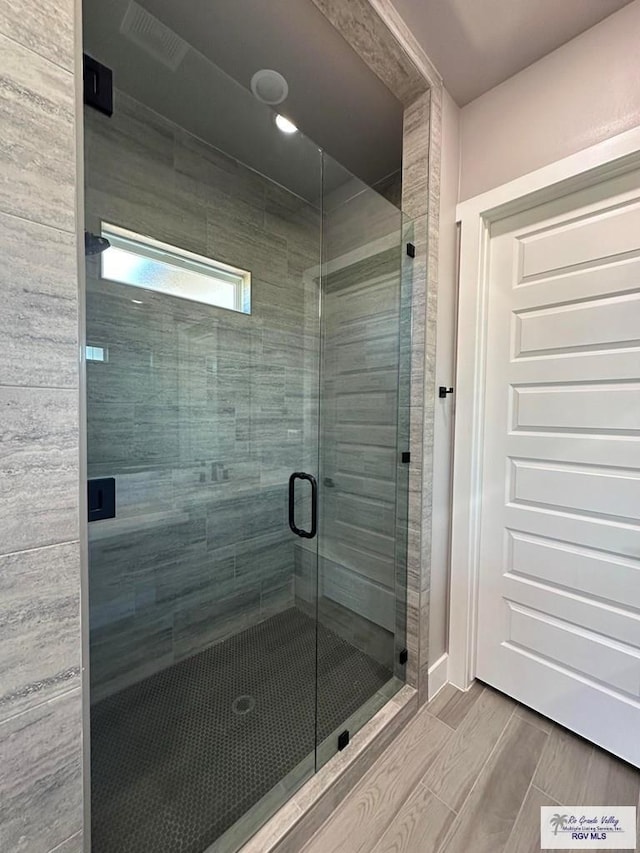 bathroom featuring a shower with shower door