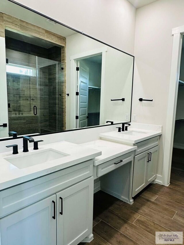 3601 Mattie Ln, Harlingen, TX 78550 - bathroom with a spacious closet, double vanity, and wood finished floors