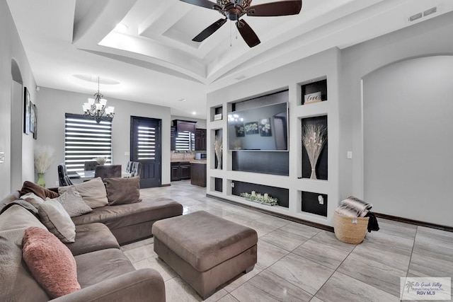 living area featuring arched walkways, a tray ceiling, visible vents, and ceiling fan with notable chandelier