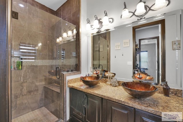 full bathroom with double vanity, a sink, and a stall shower