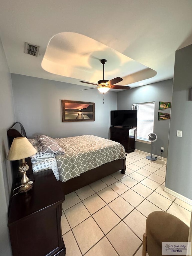 6020 Rusty Nail Dr, Brownsville, TX 78526 - bedroom with light tile patterned floors, a raised ceiling, and a ceiling fan