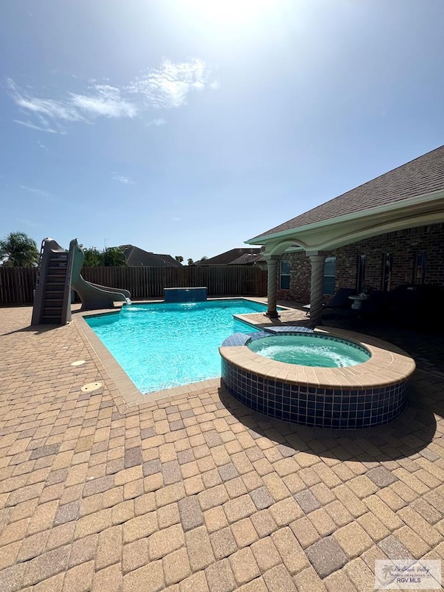 6020 Rusty Nail Dr, Brownsville, TX 78526 - view of pool featuring a water slide, a pool with connected hot tub, and a patio area