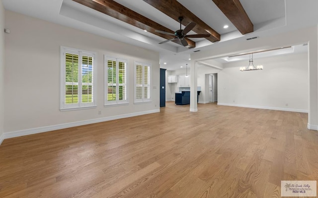 8005 King Sago Ct, Harlingen, TX 78552 - unfurnished living room featuring a ceiling fan, a chandelier, beamed ceiling, and light wood-type flooring