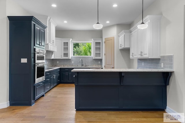 8005 King Sago Ct, Harlingen, TX 78552 - kitchen with a peninsula, white cabinets, glass insert cabinets, decorative backsplash, and recessed lighting