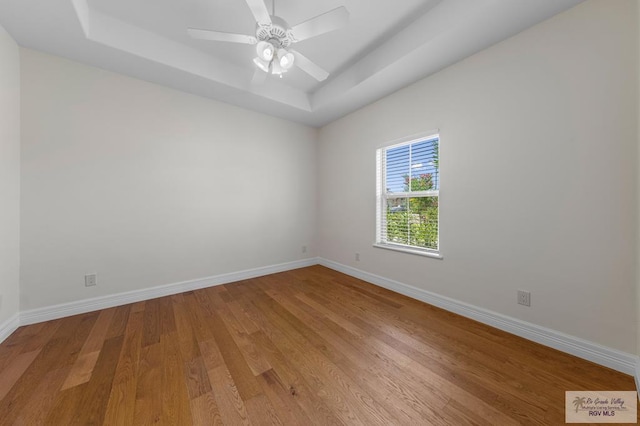 8005 King Sago Ct, Harlingen, TX 78552 - empty room featuring a raised ceiling, light wood-style floors, and a ceiling fan